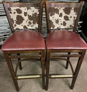 DESCRIPTION: (2) 30" WOODEN BAR STOOLS W/ MAROON PADDED SEATS AND COW PRINT BACKS. SIZE: 30" T THIS LOT IS: SOLD BY THE PIECE QTY: 2