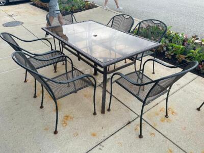 60" X 37" GLASS TOP PATIO TABLE W/ (6) WROUGHT IRON CHAIRS.
