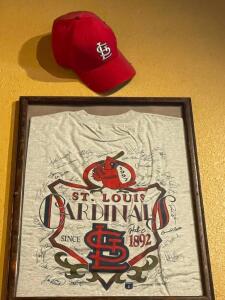 DESCRIPTION: SIGNED CARDINAL T SHIRT FRAMED AND CARDINAL HAT ADDITIONAL INFORMATION NEED LADDER FOR REMOVAL LOCATION: SEATING THIS LOT IS: ONE MONEY Q