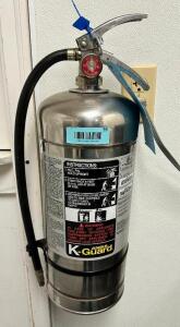 WET CHEMICAL FIRE EXTINGUISHER W/ WALL MOUNTED HOOK.