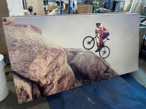 96" X 48" ACOUSTICAL SOUND PANEL W/ CUSTOM FABRIC COVERING. MOUNTAIN BIKER