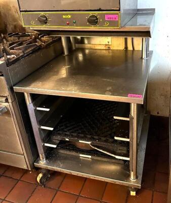 DESCRIPTION: STAINLESS WORK TABLE WITH STORAGE AND RISER ON CASTERS SIZE: 28.5"X30"X30" LOCATION: KITCHEN QTY: 1