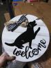 DESCRIPTION: (3) WELCOME SIGN, WITH DOG BRAND/MODEL: FARMLYN CREEK INFORMATION: WHITE WITH BLACK SIZE: ROUND RETAIL$: $19.49 EA QTY: 3 - 3