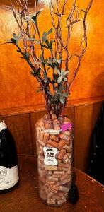 DESCRIPTION GLASS VASE W/ CORKS AND FAUX PLANT. LOCATION ROOM 3 QTY 1